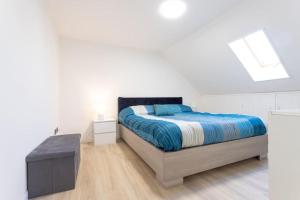 una camera bianca con letto e lucernario di Motor Valley PentHouse - B&B Al Caminetto a Modena