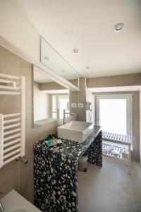 bagno con lavandino e specchio di Profumi di Primavera Luxury Rooms a Matera