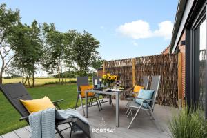 une terrasse avec des chaises et une table fleurie. dans l'établissement Grünwald, à Emmelsbüll-Horsbüll