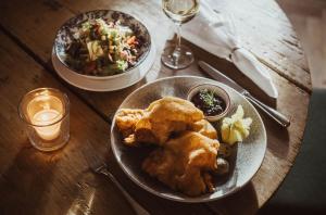 a wooden table with two plates of food on it at Romantik Spa Hotel Elixhauser Wirt in Elixhausen