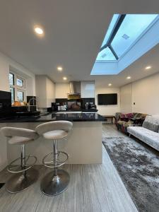 a kitchen with two bar stools in a living room at Cozy 2 Bed Property in High Wycombe Tn in High Wycombe