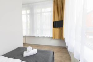 a bedroom with a bed with a towel on it at Zefiro Na Gnilnej in Gdańsk