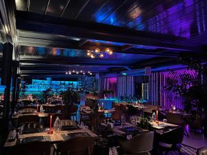 Hotel Zurich Istanbul Old City في إسطنبول: غرفة طعام بها طاولات وكراسي وإضاءة أرجوانية