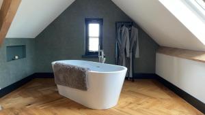een badkamer met een wit bad op zolder bij B&B Il Settimo Cielo in Someren