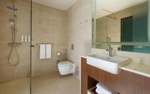 a bathroom with a sink and a toilet and a shower at Courtyard by Marriott Baku in Baku