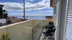 a balcony with two chairs and a view of the ocean at VCS House by Madeira Holiday in Funchal