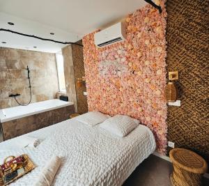 um quarto com uma cama e uma parede coberta de flores em L'expérience LOVE ROOM em Saint-Jean-Bonnefonds