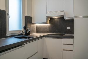 a kitchen with white cabinets and a sink at Residenza degli Speziali in Florence