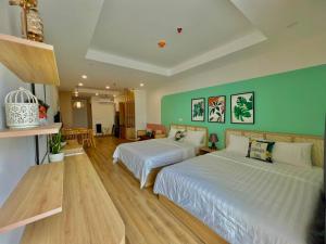 - une chambre avec 2 lits et un mur vert dans l'établissement TMS Beachfront Apartment Quy Nhon Bay, à Quy Nhơn