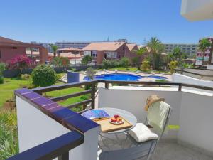 una mesa en un balcón con vistas a la piscina en Bayuca 109 By Pride Holiday Rentals, en Playa del Inglés