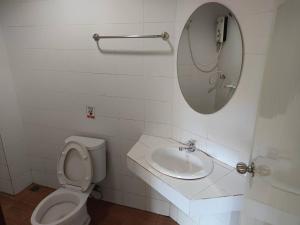 a bathroom with a toilet and a sink and a mirror at Chandra Hostel Koh Tao in Koh Tao