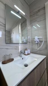 a bathroom with a white sink and a mirror at VCS House by Madeira Holiday in São Gonçalo