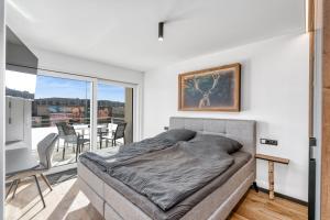 ein Schlafzimmer mit einem Bett und einem Balkon in der Unterkunft Seequartier 1 - neu & hochwertig in Friedrichshafen
