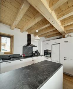 a kitchen with white cabinets and a black counter top at Chalet Le Clapière in La Toussuire