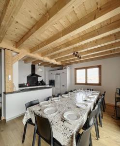 a long dining room with a long table and chairs at Chalet Le Clapière in La Toussuire