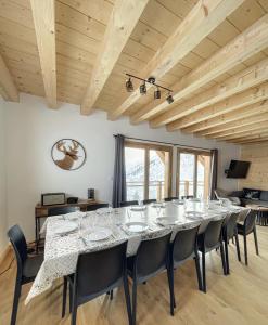uma grande sala de jantar com uma mesa longa e cadeiras em Chalet Le Clapière em La Toussuire