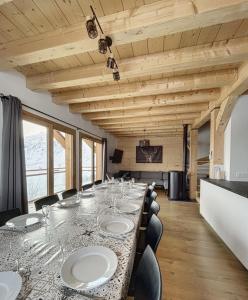 uma longa sala de jantar com uma longa mesa e cadeiras em Chalet Le Clapière em La Toussuire