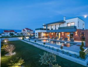 a house with a large backyard with a swimming pool at Villa Royal Sands in Privlaka