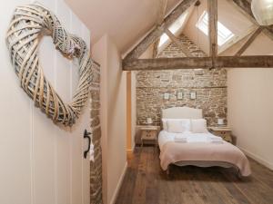 1 dormitorio con cama y pared de ladrillo en Meadow Barn en Leominster