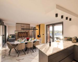 a kitchen and living room with a table and chairs at Villa Royal Sands in Privlaka