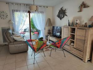 een woonkamer met 2 kleurrijke stoelen en een tv bij Maison Pornichètine classée 3 étoiles à 700m plage a pieds in Pornichet