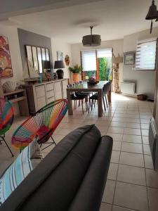 een woonkamer met een bank en stoelen. bij Maison Pornichètine classée 3 étoiles à 700m plage a pieds in Pornichet