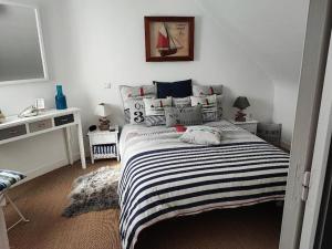 een slaapkamer met een bed met een zwart-wit gestreepte deken bij Maison Pornichètine classée 3 étoiles à 700m plage a pieds in Pornichet