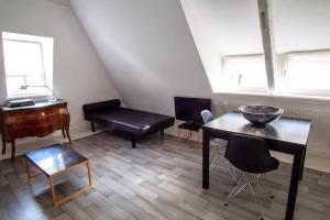 ein Wohnzimmer mit einem Tisch und einem Klavier in der Unterkunft 8 rue de l'Argile - Studio climatisé in Straßburg