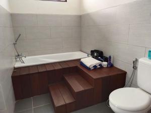 a bathroom with a bath tub and a toilet at Villa Waimea in Uluwatu