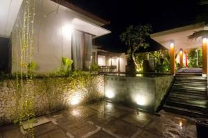 a house with a courtyard at night with lights at Villa Waimea in Uluwatu