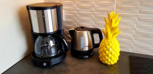 a coffee maker and a pineapple on a counter at View on Paris in Ivry-sur-Seine