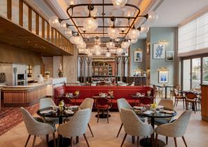 um restaurante com mesas e cadeiras e um bar em Four Seasons Resort and Residences at The Pearl - Qatar em Doha