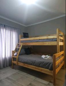 sypialnia z 2 łóżkami piętrowymi w pokoju w obiekcie OR Tambo Int Airport Rudman B Self Catering Two Bedroom Home w mieście Boksburg