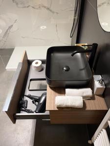 um aparelho preto sentado numa secretária na casa de banho em 7Suites em Empoli