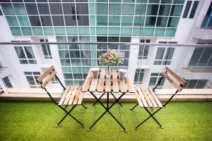 Duas cadeiras e uma mesa com flores numa varanda em Ksl City Mall D'esplanade By The one em Johor Bahru