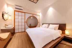 a bedroom with a large white bed and a mirror at Secret Garden Hotel in Ho Chi Minh City