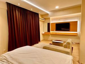a hotel room with a bed and a television at ARMERIA STAY DLF MY PAD in Lucknow
