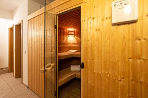 a walk in shower with wood paneled walls at Haus Strandburg - hinter Düne und Meer in Binz