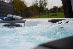 a hot tub with water pouring out of it at Ferienwohnung "iewer der Schaff" - KEINE Monteurzimmer in Burbach