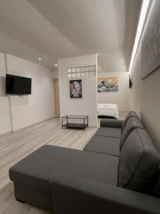 sala de estar con sofá y TV de pantalla plana en 7Suites, en Empoli