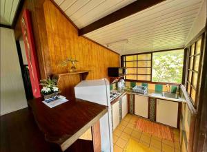 a kitchen with a white refrigerator in a room at Fare miti access private white sand beach in Moorea