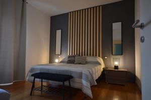 1 dormitorio con 1 cama, 1 taburete y 2 lámparas en la Bohème Peschiera luxury apartment, en Peschiera del Garda