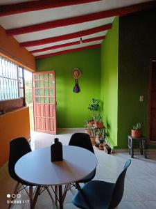 um quarto com uma mesa e cadeiras e uma parede verde em Buenavista, espacio natural em Ráquira