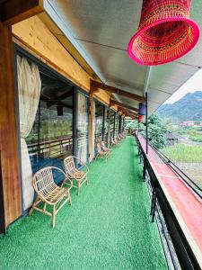 a row of chairs sitting on a train balcony at Du Gia Village Homestay-Lana in Làng Cac