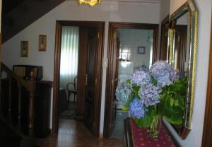 eine Vase lila Blumen auf einem Tisch in einem Zimmer in der Unterkunft Finca El Carbayal in El Campo