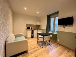 a living room with a couch and a table at LesCinqSuites/12 couchages-DABNB in Limoges +12 photos