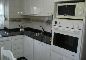 eine Küche mit einer Spüle und einer Mikrowelle in der Unterkunft Finca El Carbayal in El Campo