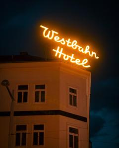 una señal de neón en la parte superior de un edificio por la noche en Hotel Westbahn, en Viena