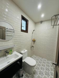 un bagno con un water, un lavandino e uno specchio di Liu Xu Homestay ll a Tainan