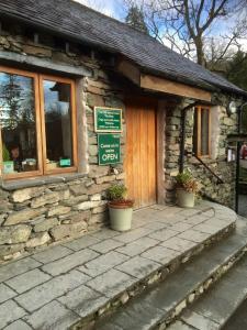 a stone building with potted plants in front of it at Tarn Hut in Rydal
